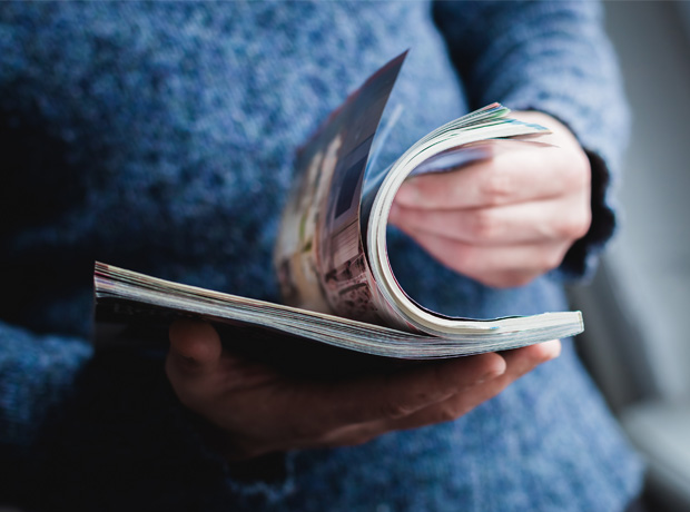 Person flipping pages of a magazine