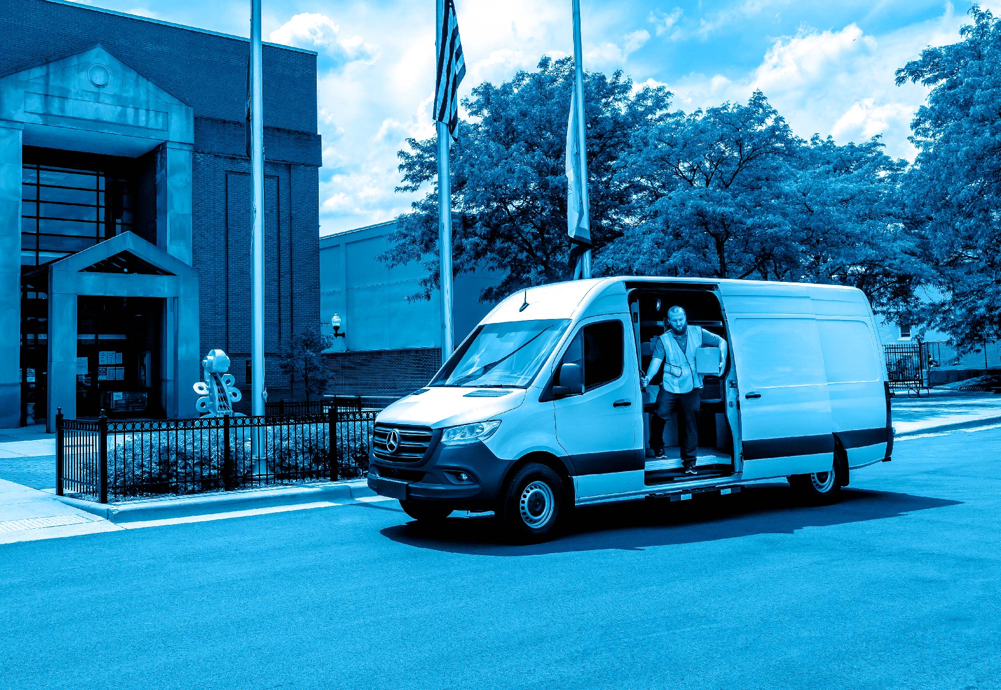 A man exiting a cargo van holding a package