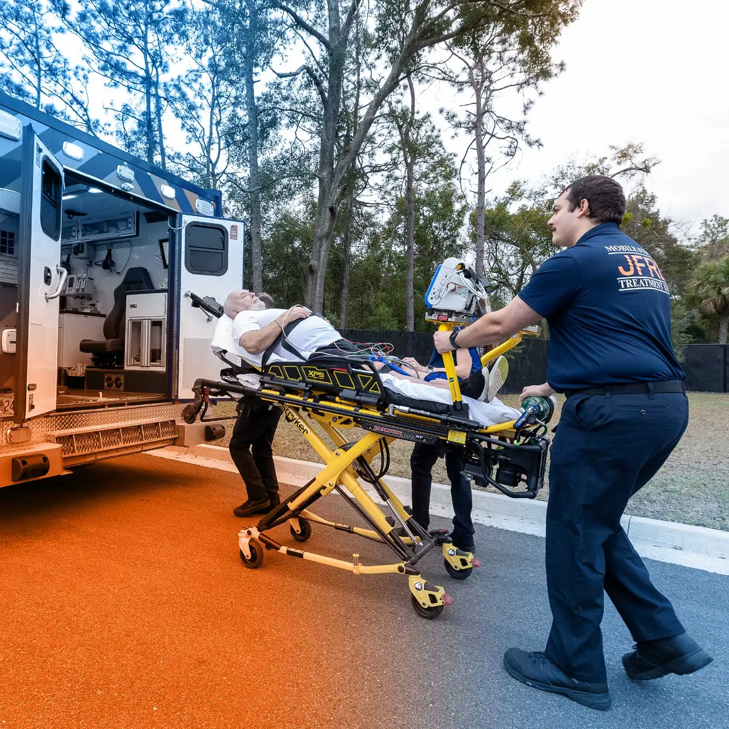 UF health stroke team pushing patient on stretcher into emergency vehicle